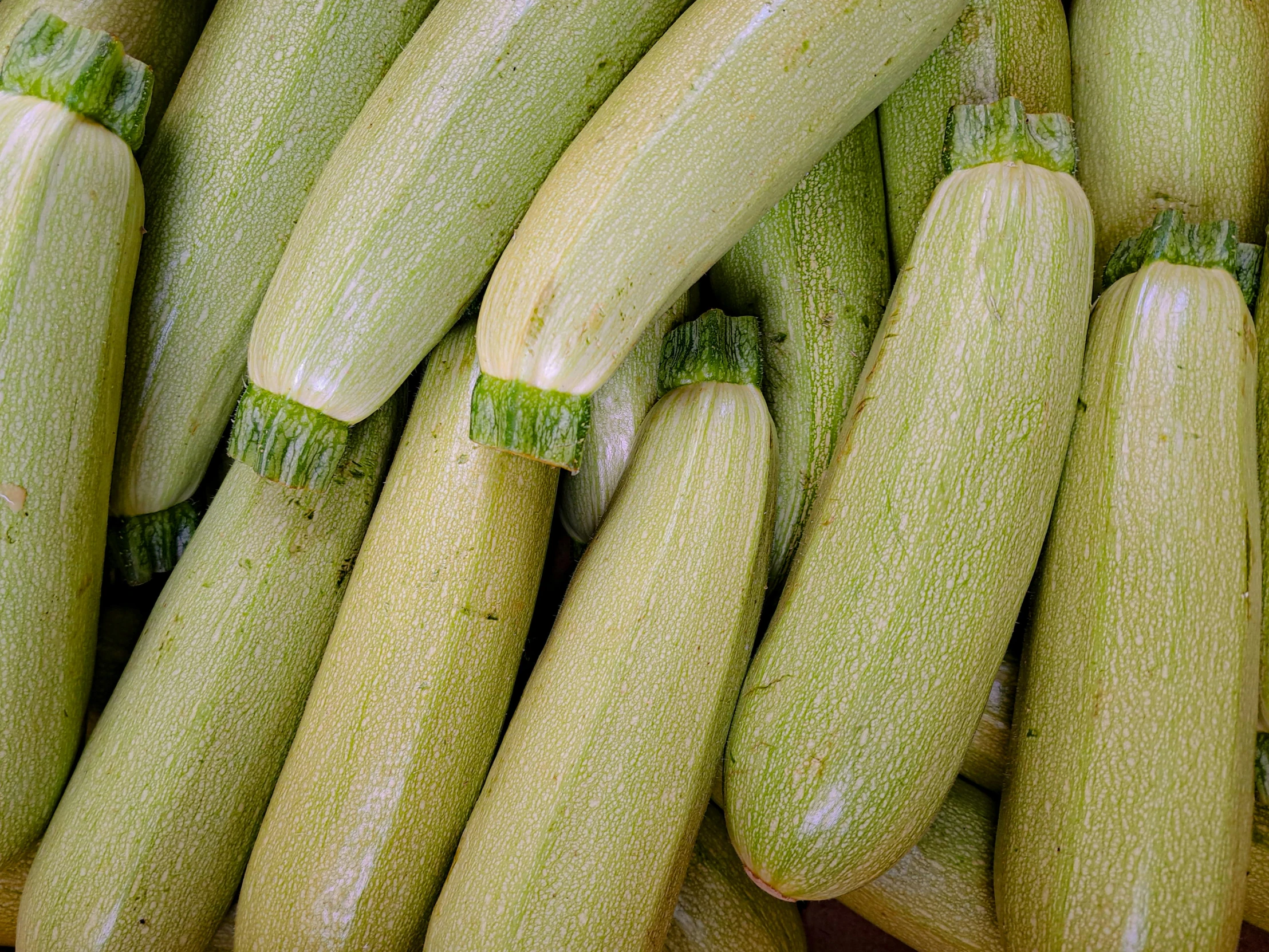 several cucumbers are in a woven basket