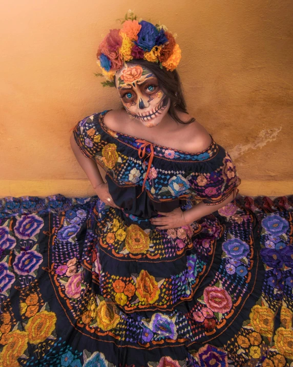 a woman with make up sitting on a colorful cloth