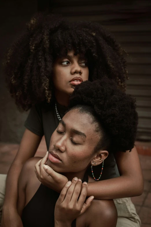 two women with afros sit down together