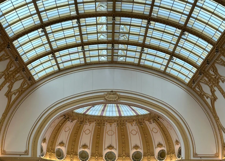 a grand looking hall with high ceilings and glass windows