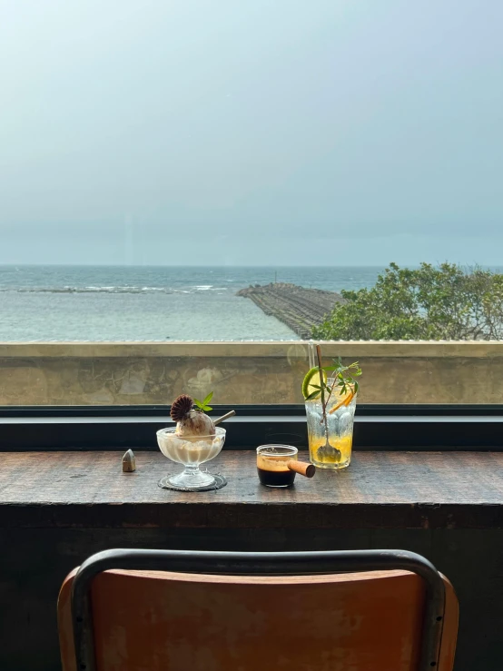 an empty chair is sitting in front of a window overlooking the ocean