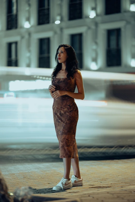 an attractive young woman posing in front of a building