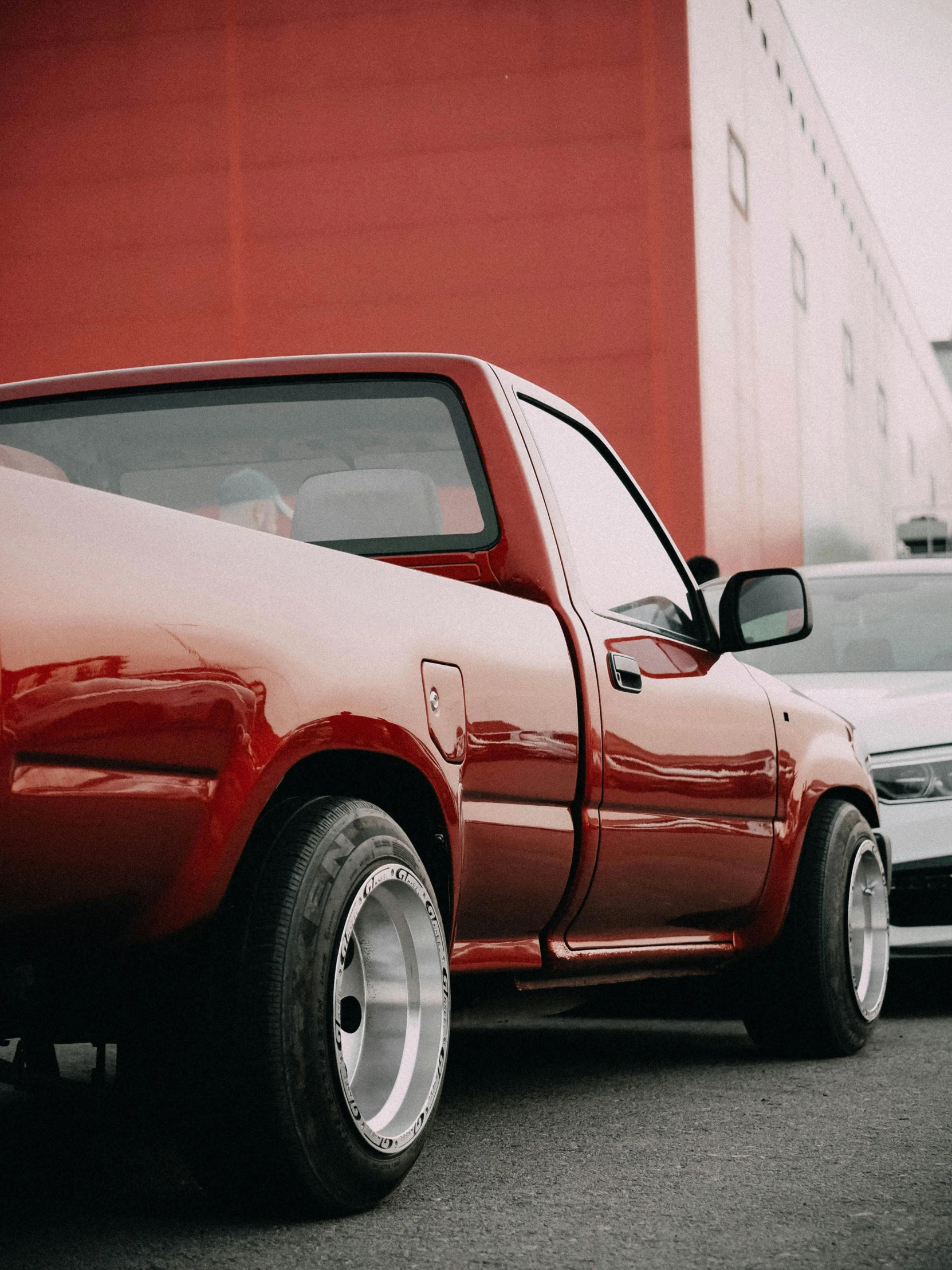 a pick up truck parked in front of a large red building