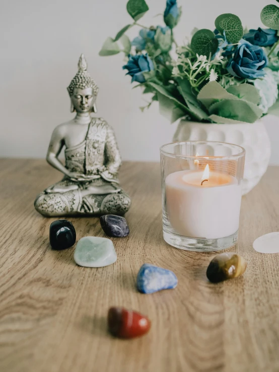 a candle on top of a wooden table next to a flower pot