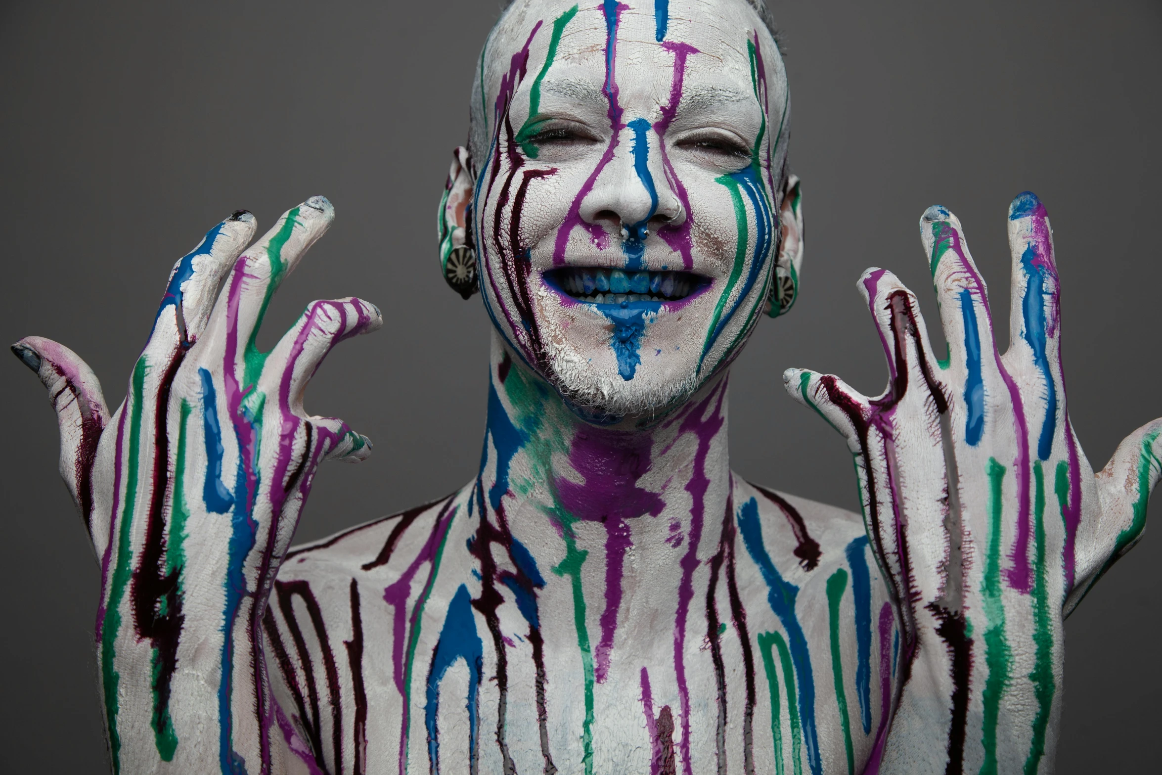 a man with painted hands and a striped shirt