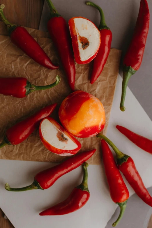 a bunch of apples and red peppers on a  board