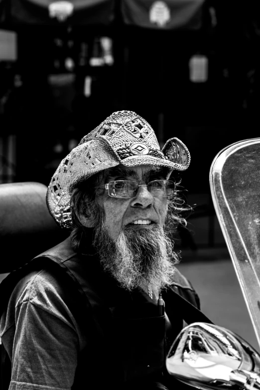 black and white po of a man with beard on motorcycle