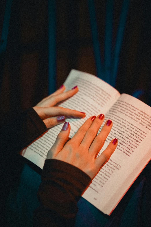 a person is reading a book in a dark room
