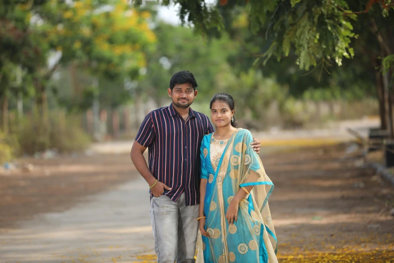 man and woman standing next to each other in the park