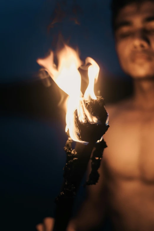 a man holding a burning object in his hand