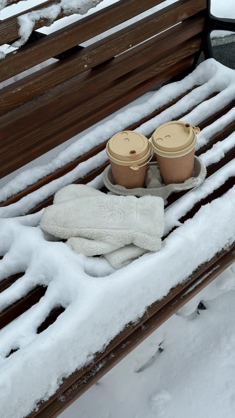 coffee cups are in a cup holder on a bench