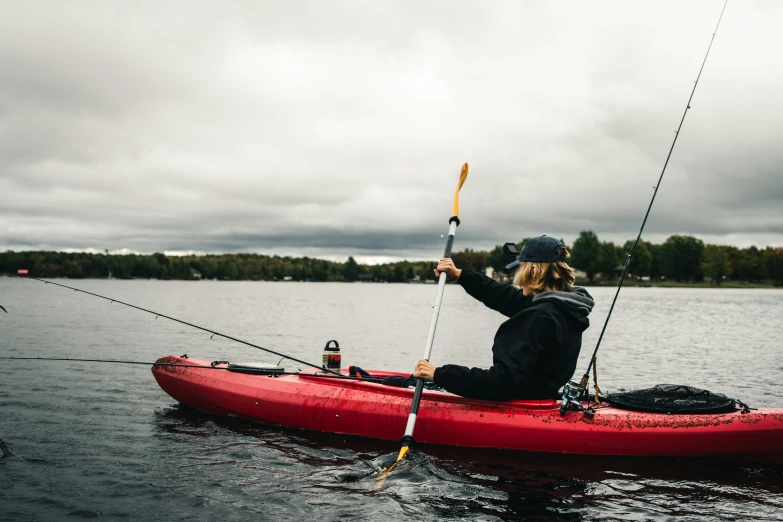 a person sitting in a red canoe in the water