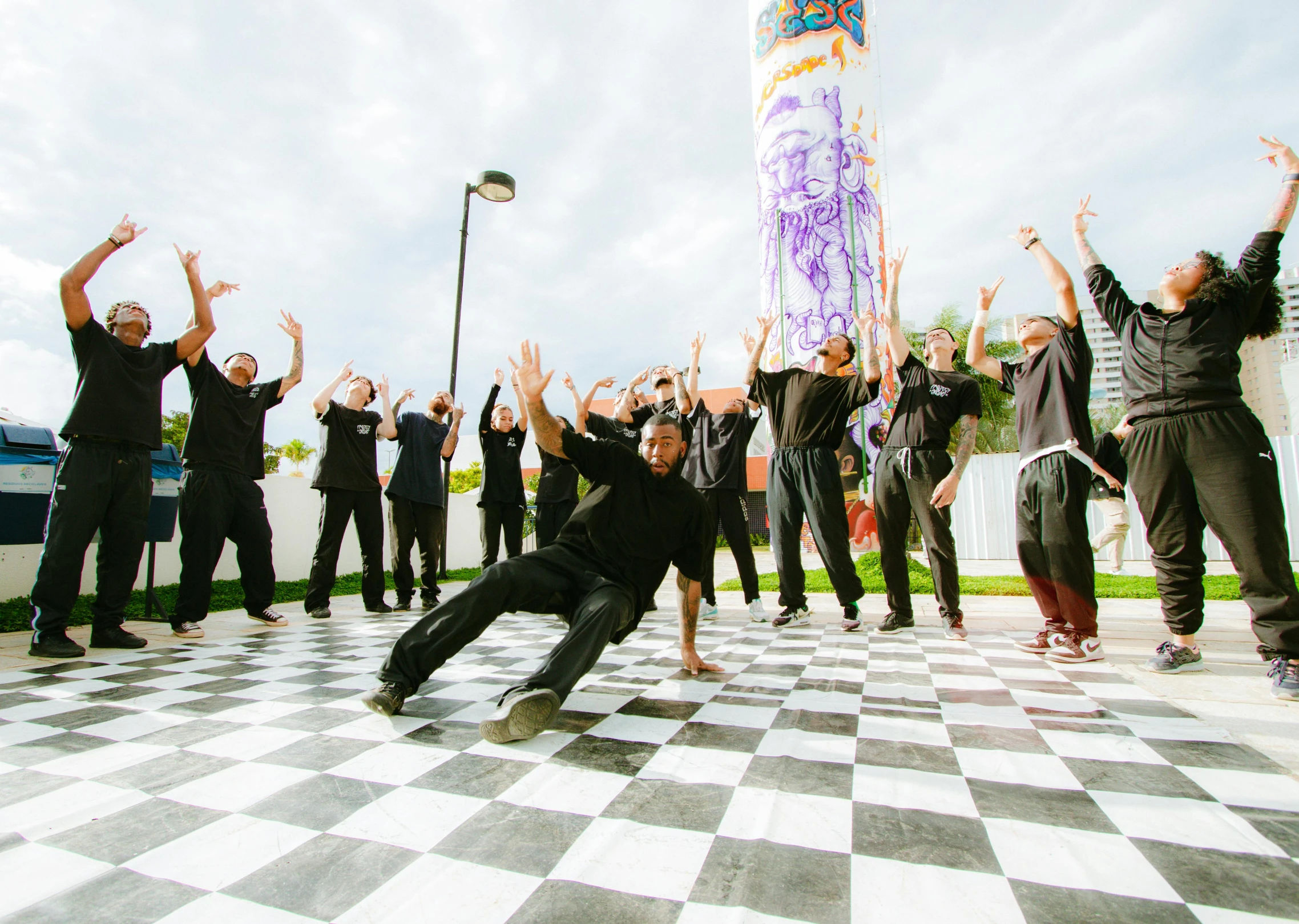 a large group of people that are dancing on a checkered floor