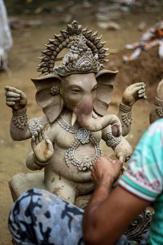 a man touching a statue of an elephant