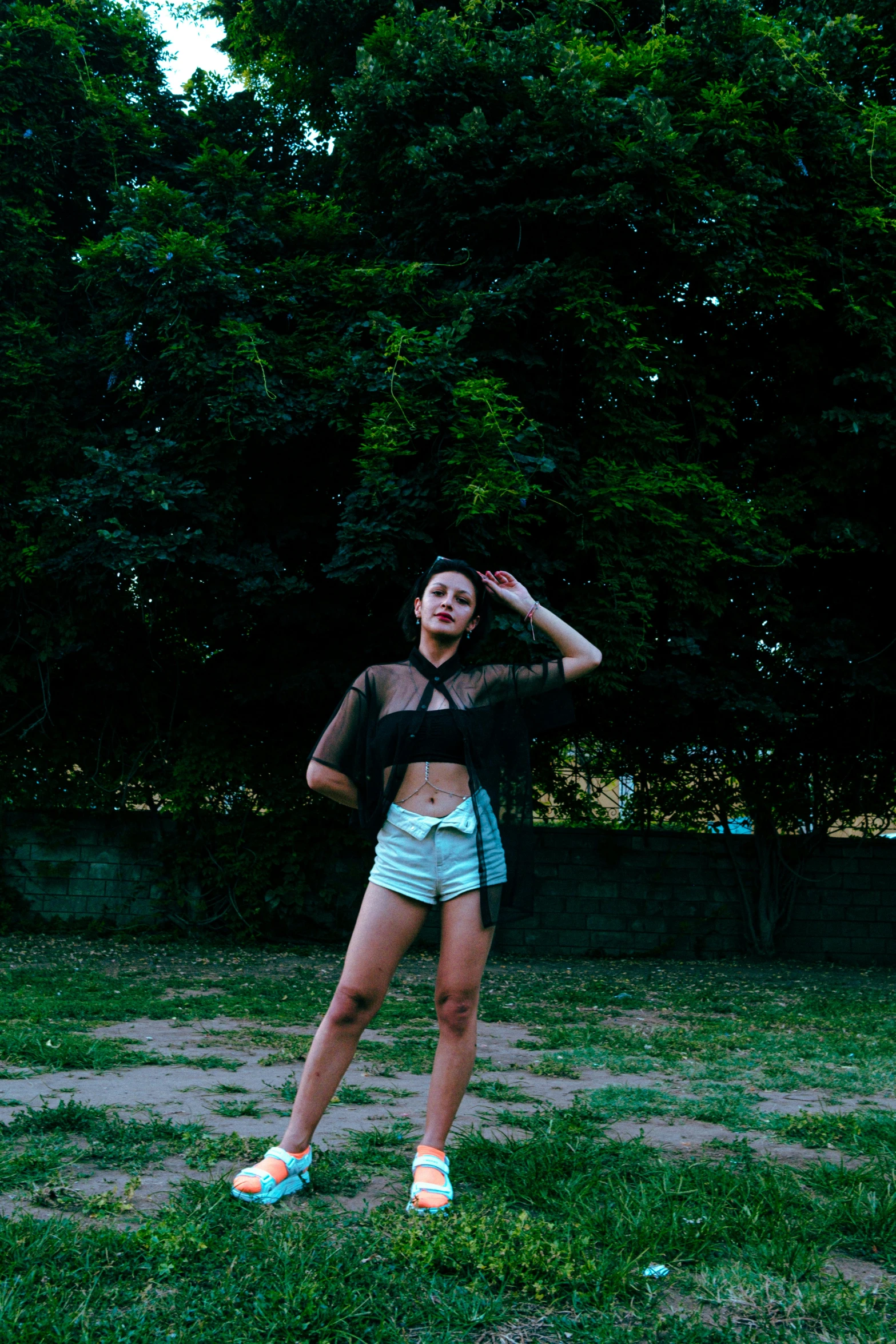 a woman posing with trees in the background