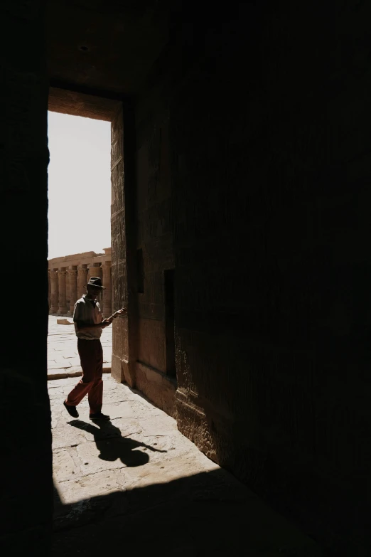 man in the doorway of an old building with a black hat