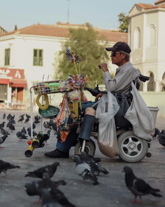 man on a motorbike surrounded by pigeons on the street