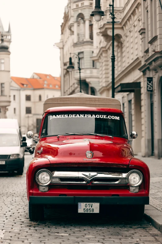 an old red truck sitting in the street