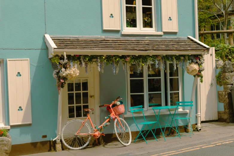 the pink bicycle is parked outside a blue house