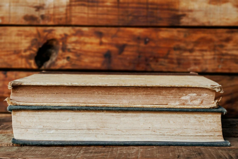 two old books are sitting on a table