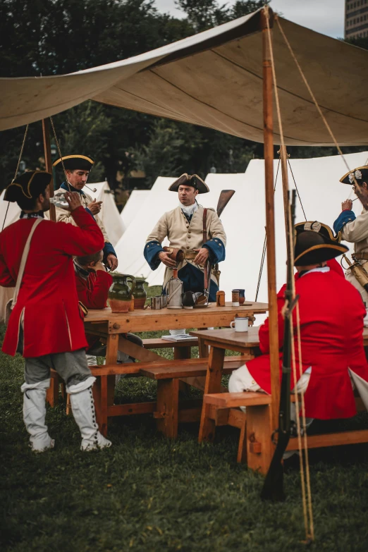 people in uniform are sitting around a picnic table