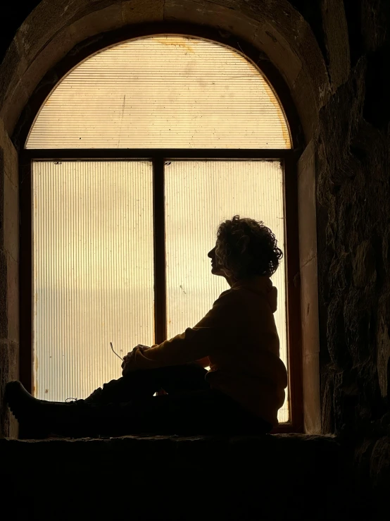 a woman sitting in front of an open window