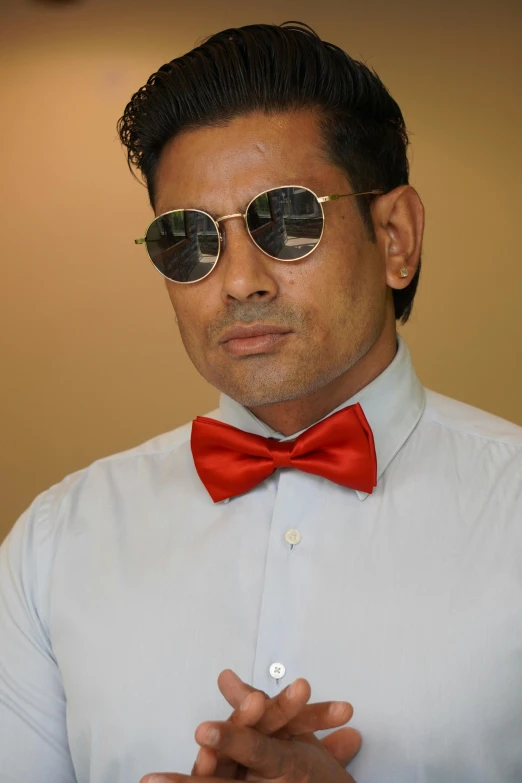 a man wearing sunglasses and a bow tie