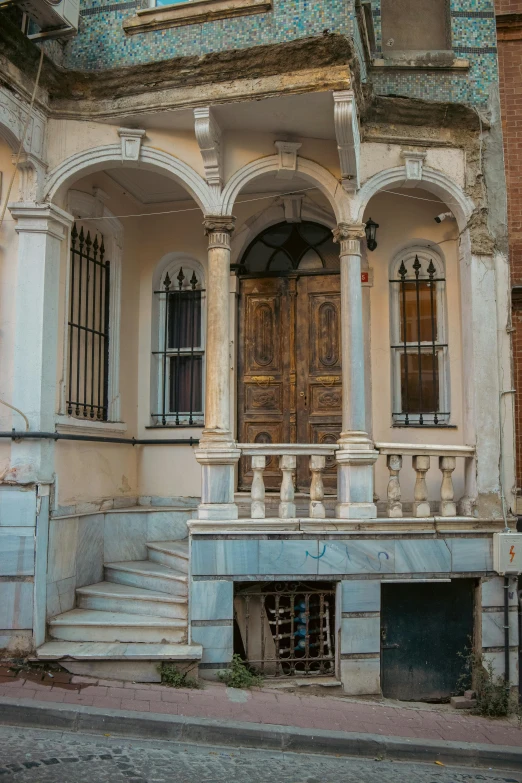 a dilapidated building with a wooden door in a foreign country