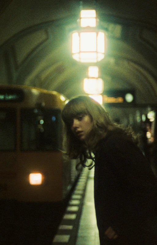 a female standing next to a train at a station