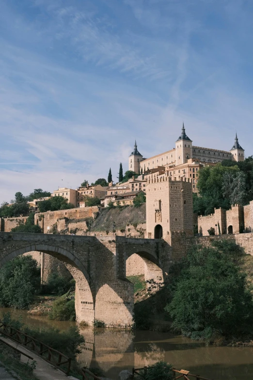 a very old stone bridge that spans the width of a river