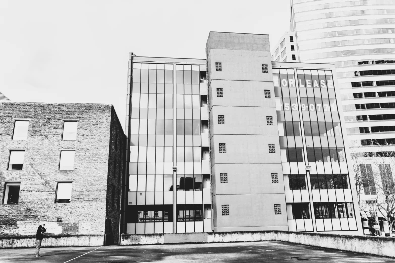 black and white po of old buildings next to tall buildings