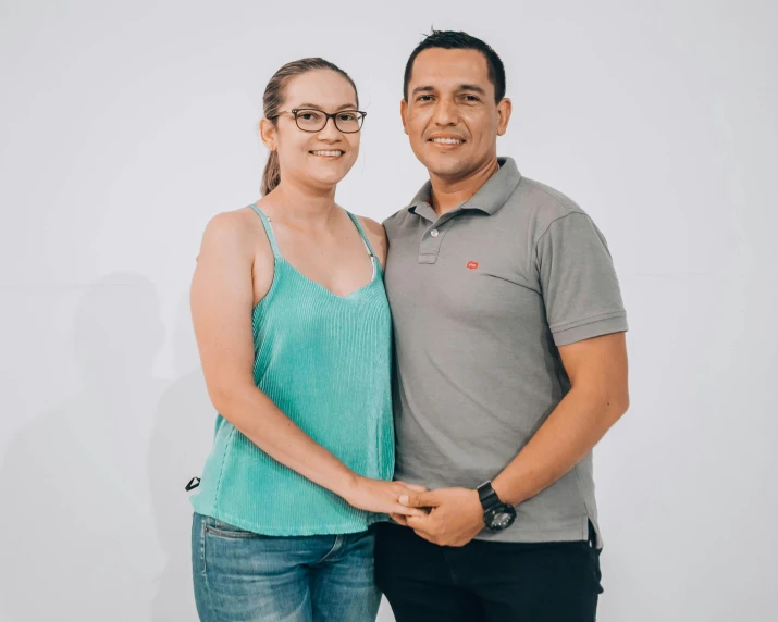 a couple posing for the camera in front of a white background