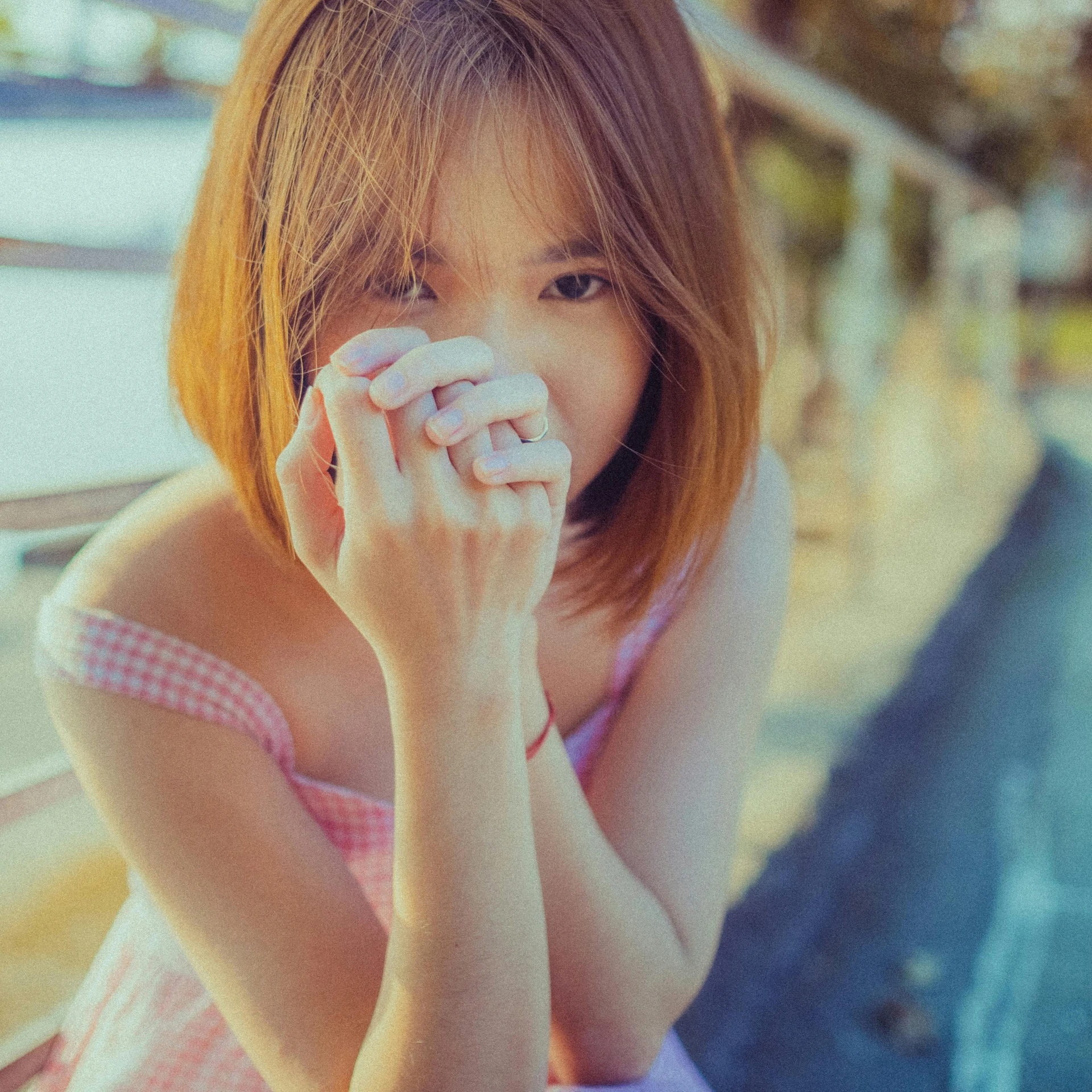 a woman sitting down covering her face with a tissue