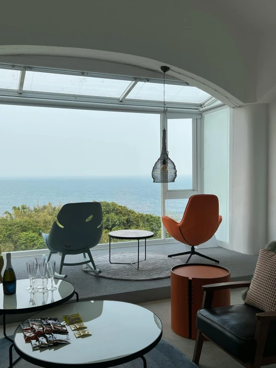 a living room with a table, chairs, and ocean view