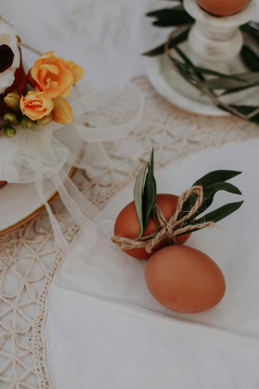 eggs tied to a rope sitting on a doily with a decorative arrangement on top