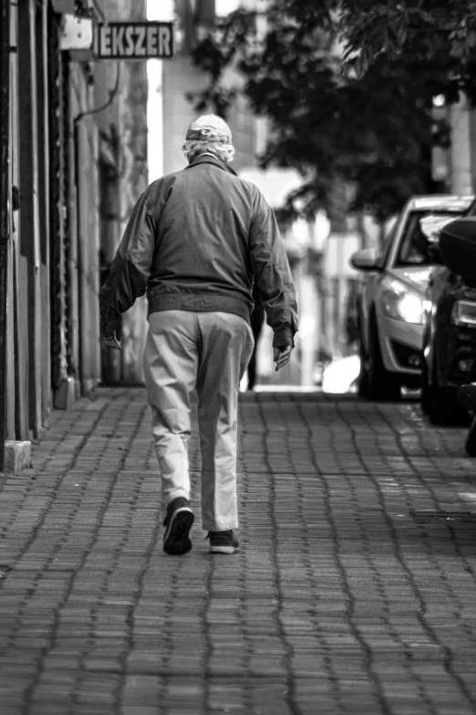 a man walking down a city street while holding a bag