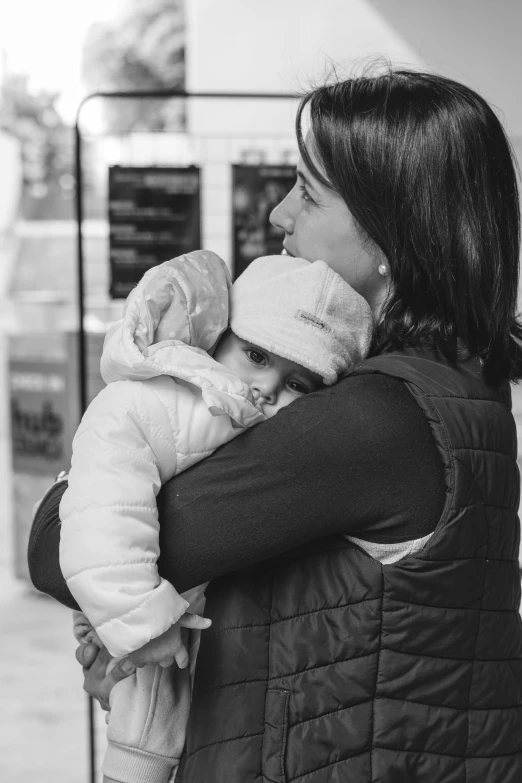 a woman holding a child and looking away