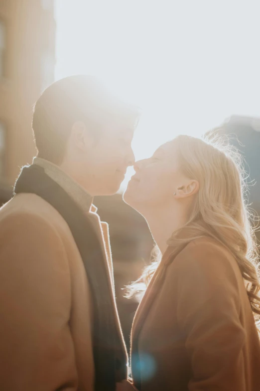 two people are standing close together in the sun