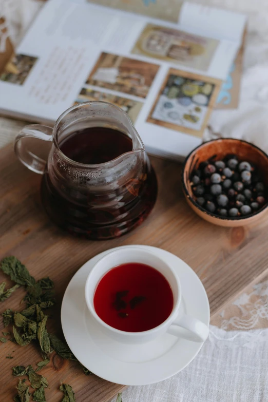 a cup of tea, a small plate with berries on a table