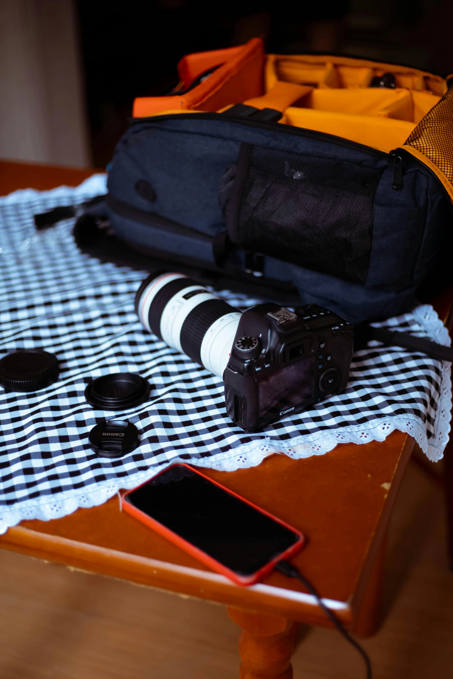 a table topped with a piece of luggage next to a cell phone