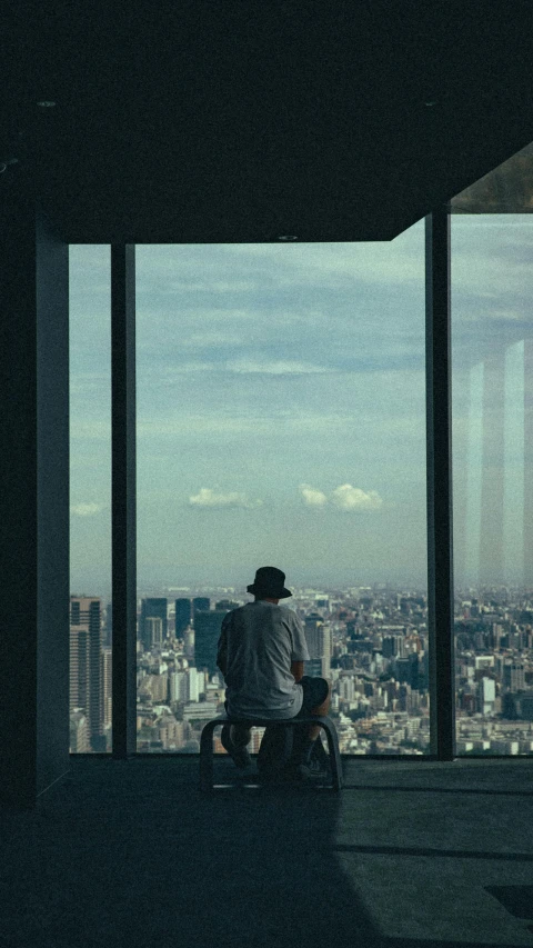 a man sitting on a chair looking out over the city