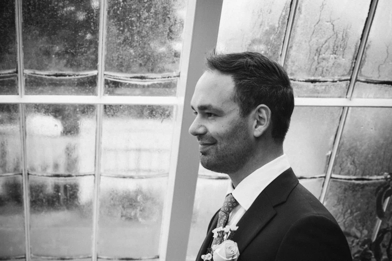 a man standing near a window smiling for the camera