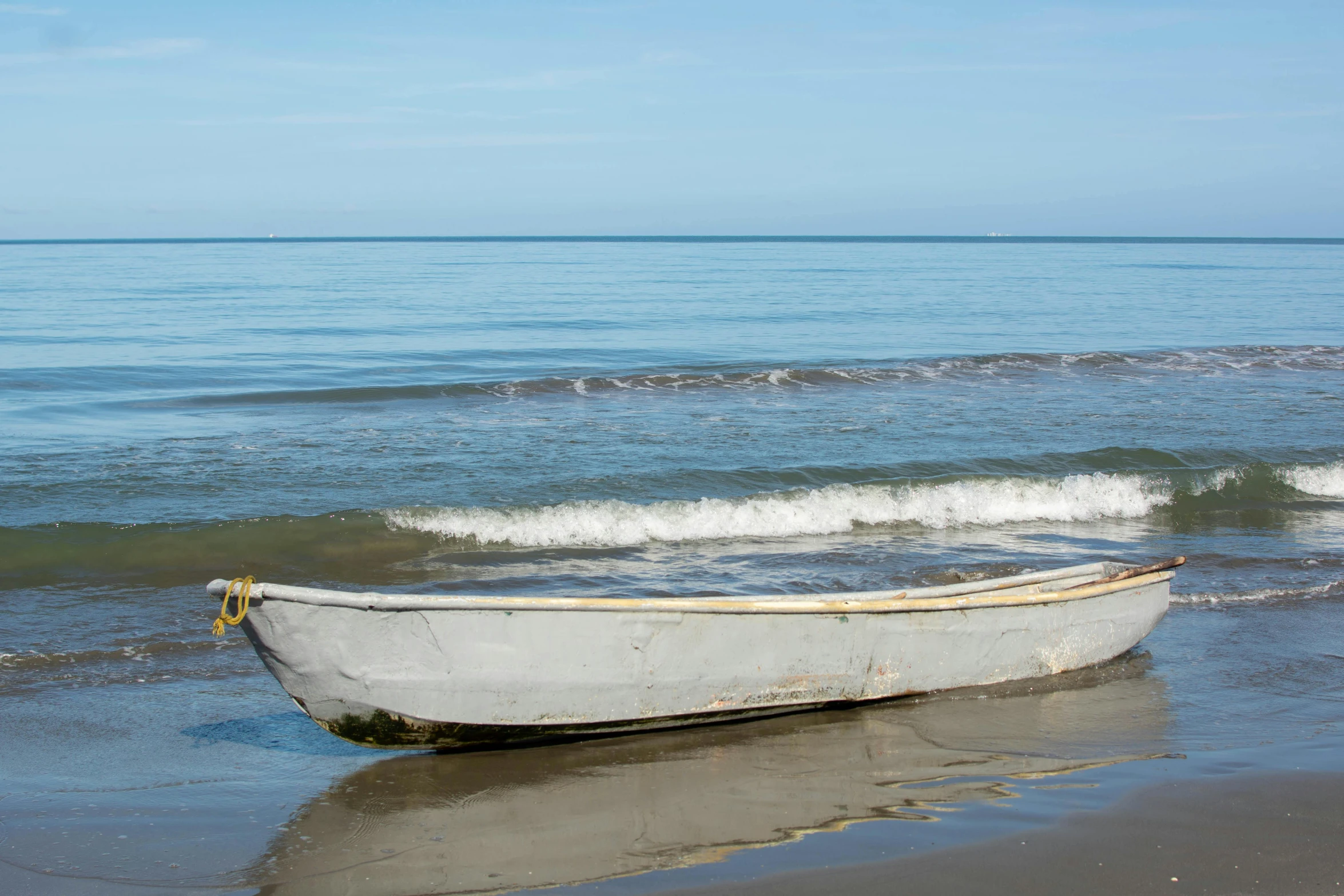 a small boat sits on the shore at the beach