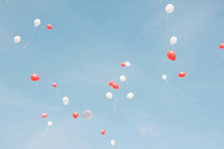 white and red balloons are floating up into the sky