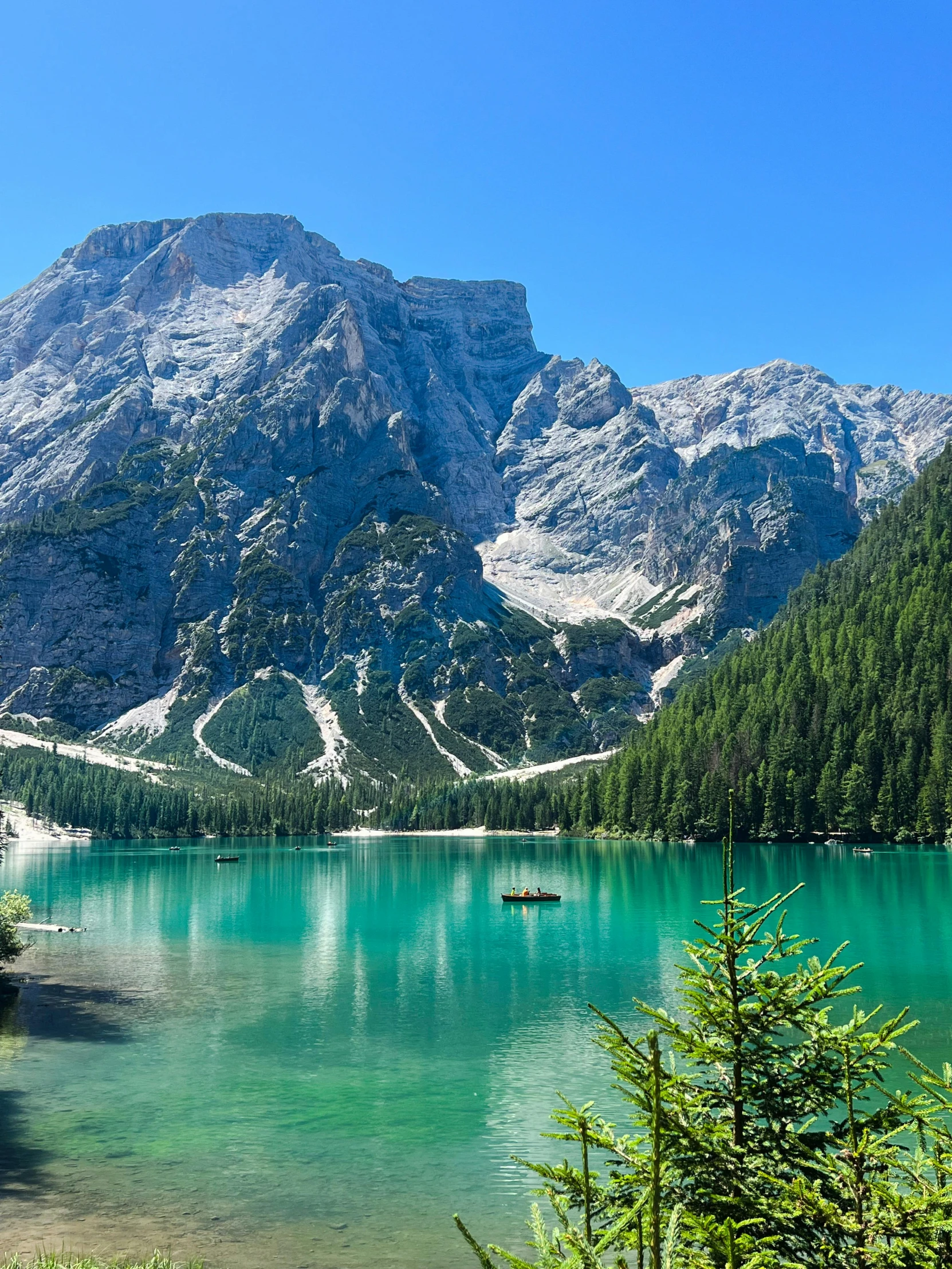 a couple of boats floating down a lake on top of a mountain