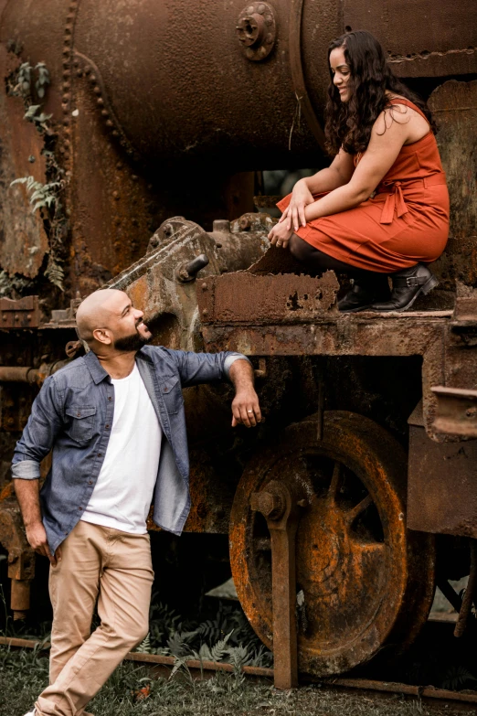 a woman standing next to a man by an old train