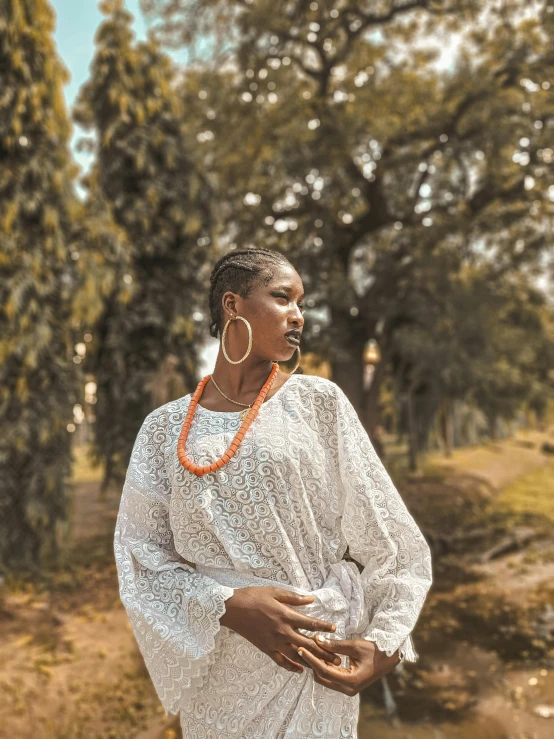 a woman standing under a tree covered hillside