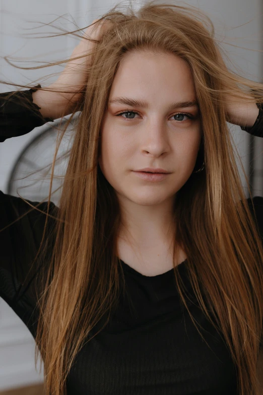 a young woman with long hair holding her head