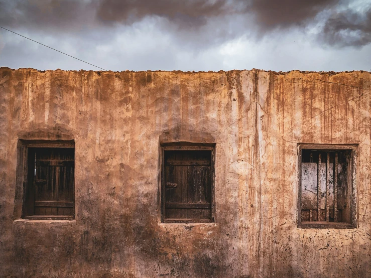 a close s of two windows on a stucco building