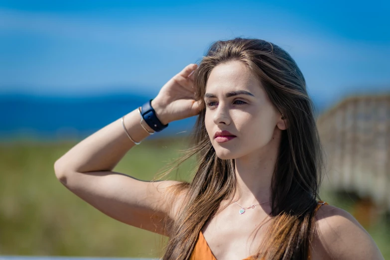 woman looking down while standing next to a fence